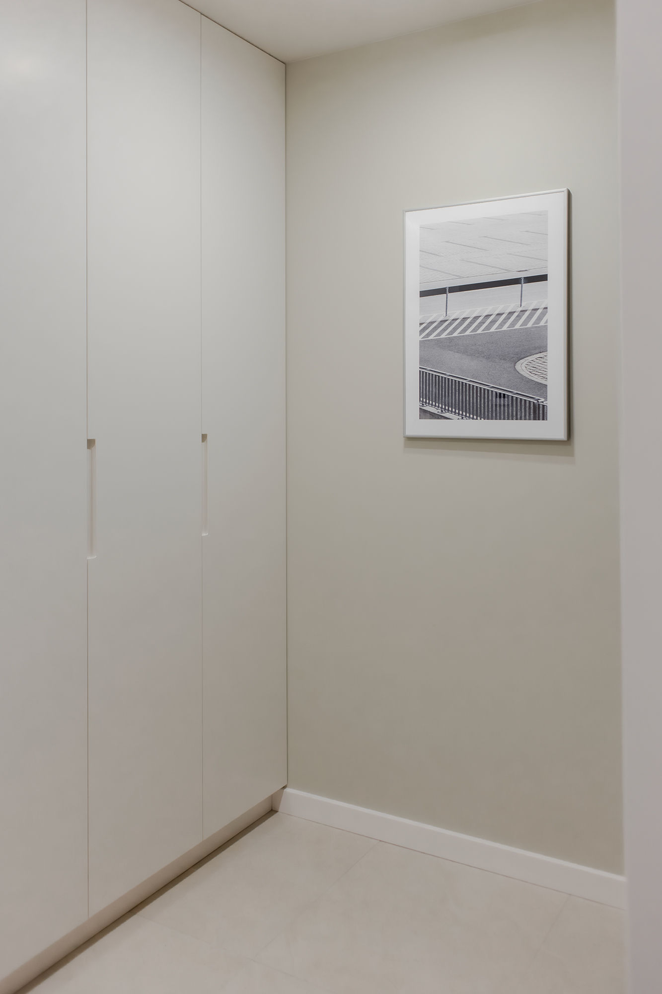 Dzięki skróceniu długiej i niefunkcjonalnej wnęki w korytarzu, zostały poprawione proporcje mieszkania. Fotografia na ścianie jest autorstwa Mateusaz Gzika z Decotive.